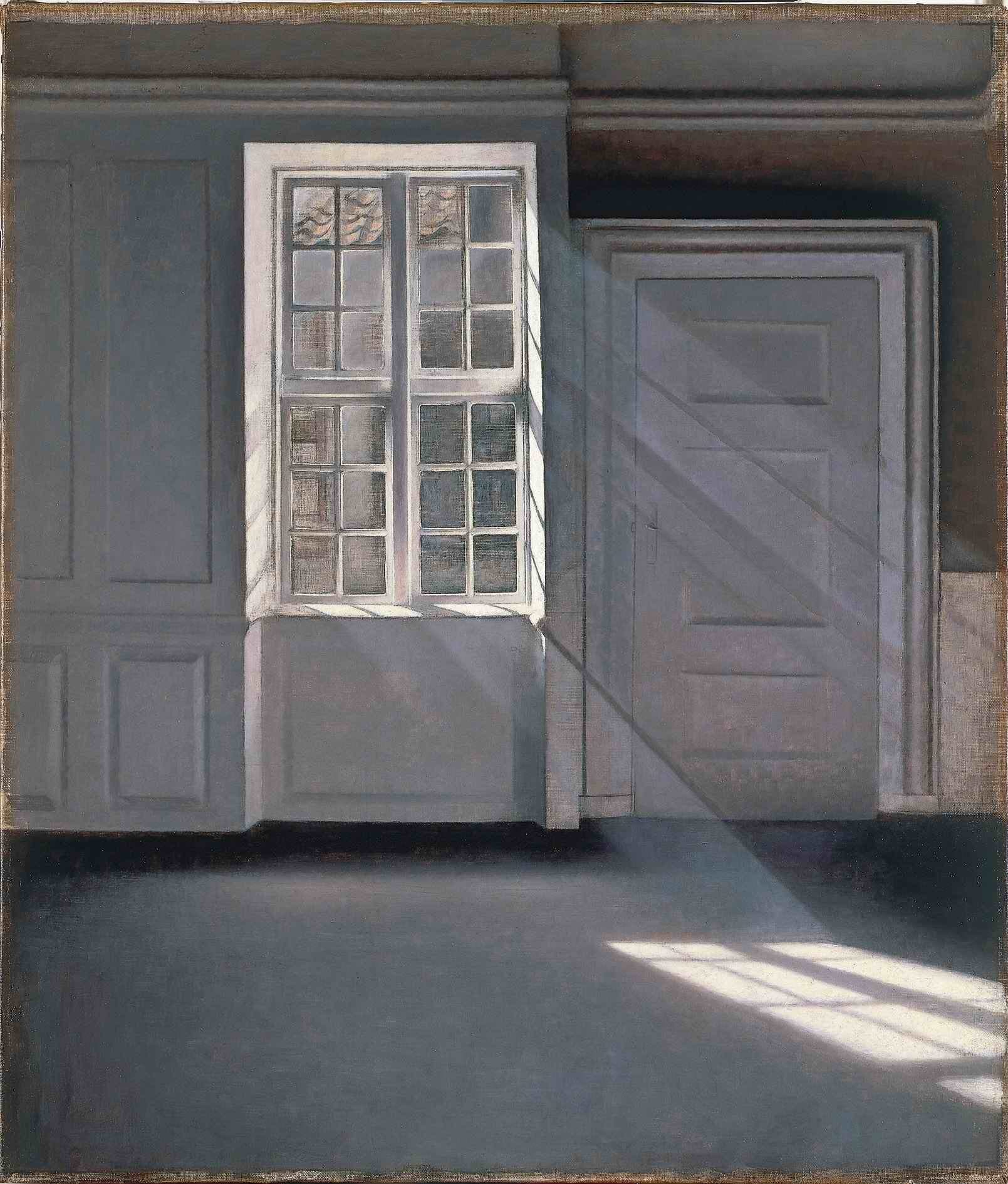 Sala vazia de paredes claras, com a luz de uma janela desenhando retângulos no assoalho.